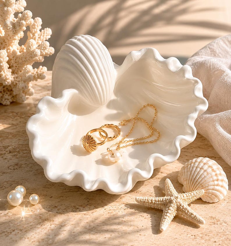 Seashell dish holding gold rings and a necklace